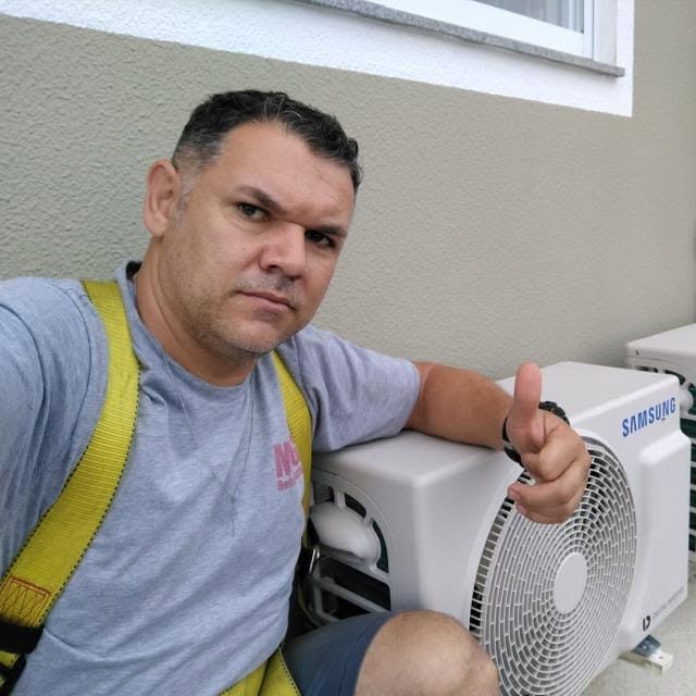 Técnico da MFG Refrigeração ao lado de uma condensadora Samsung instalada